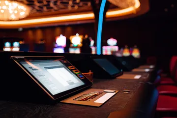 A man celebrating a winning moment on his laptop while gaming symbols float around him, capturing the excitement of 1777BET888 games.